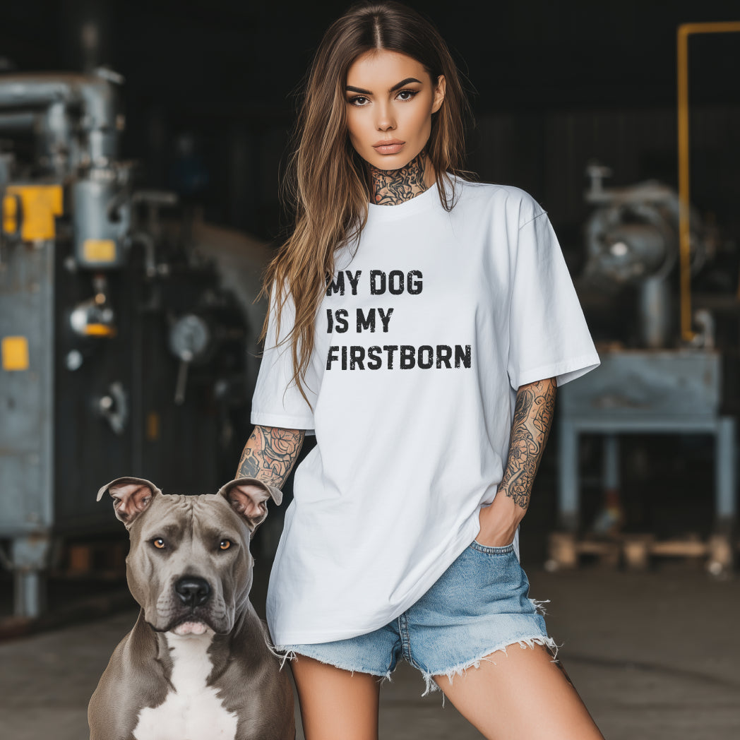 brunhårig tjej med en vit t-shirt med texten my dog is my firstborn, bredvid henne sitter en grå american bully